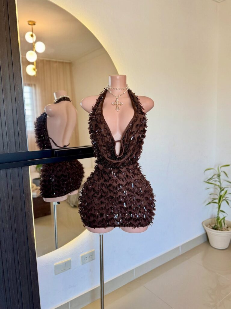 Black sequined halter-neck mini dress on a mannequin with a silver cross necklace