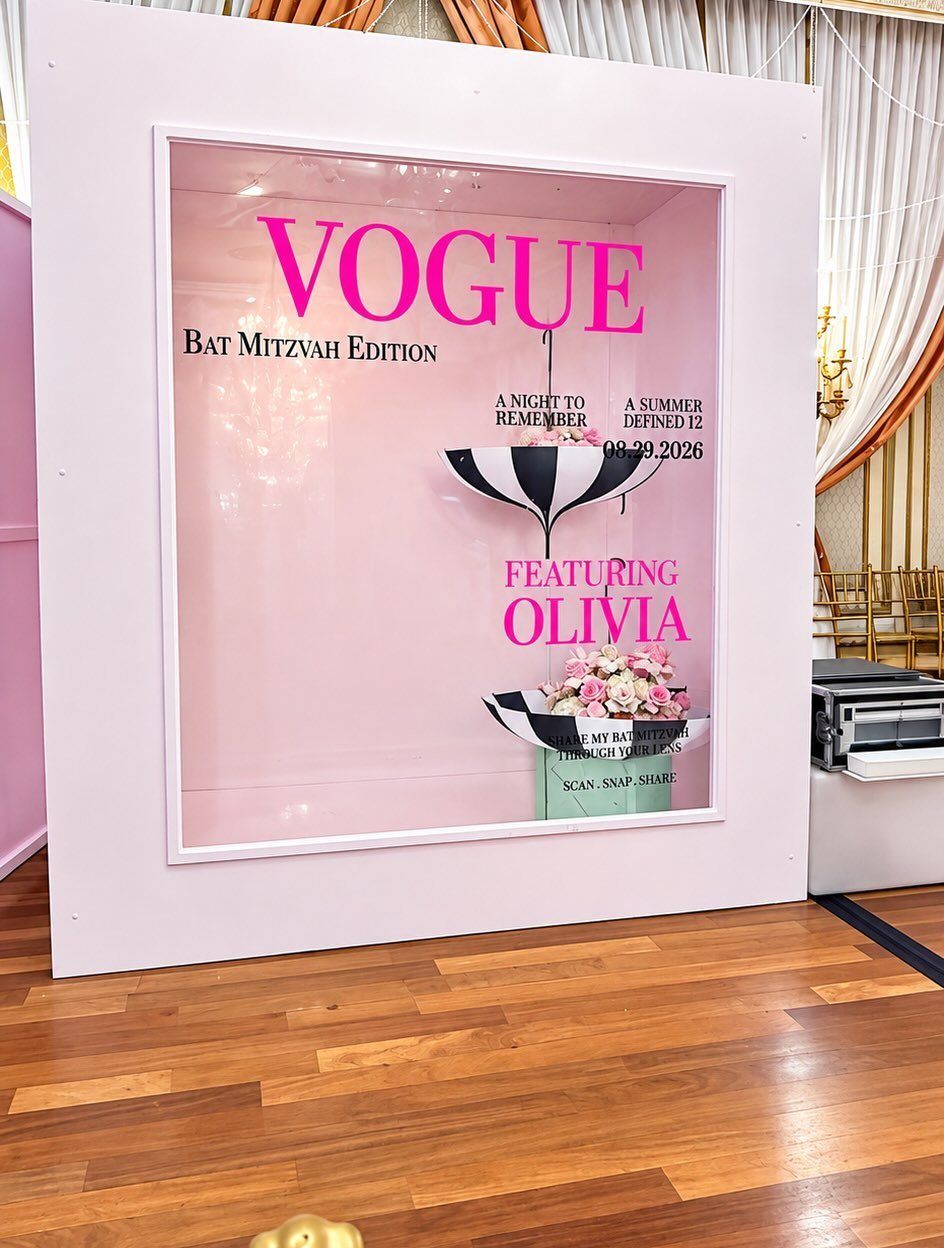 Vogue themed bat mitzvah photo booth with pink walls and floral accents