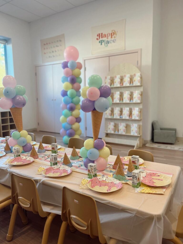 Ice cream social decorations featuring pastel balloon cones and colorful table settings.