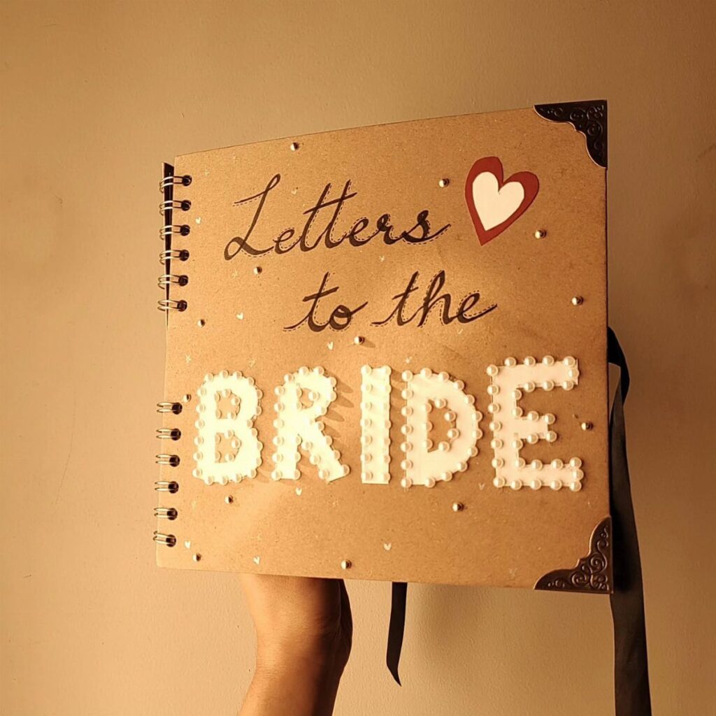 Brown cardboard scrapbook cover with pearl lettering saying Letters to the Bride.
