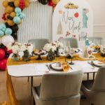 New York themed party table with yellow runner and city illustration backdrop
