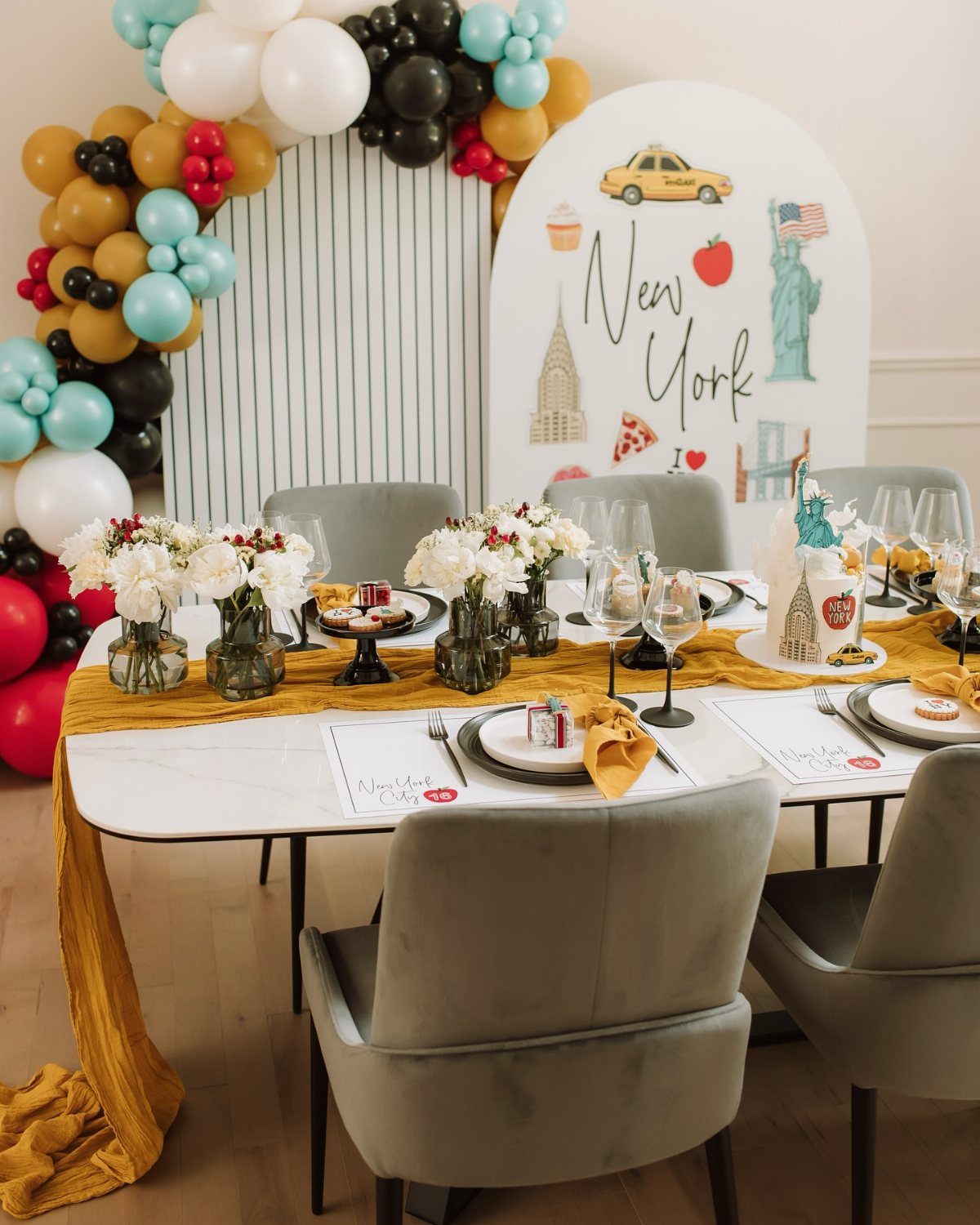 New York themed party table with yellow runner and city illustration backdrop