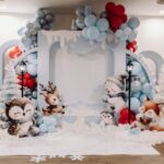 Winter party setup with blue balloons, white trees, and cute arctic animal figures.