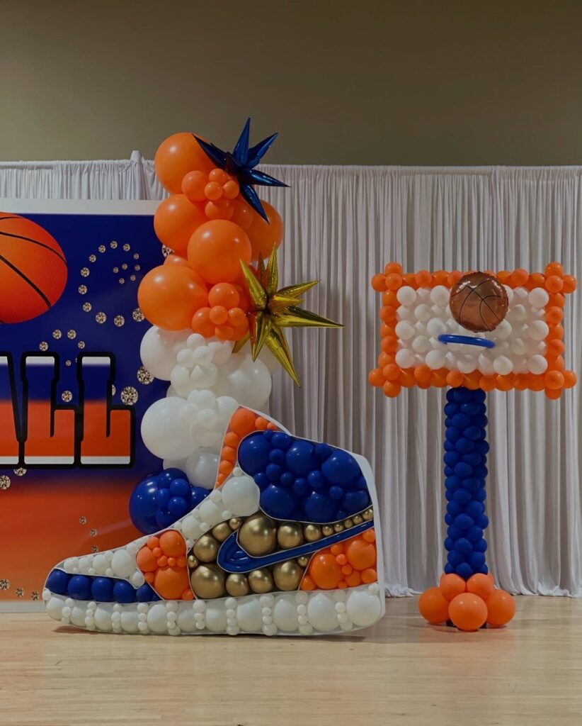 Balloon sculpture of a high-top sneaker and basketball hoop for event decor.