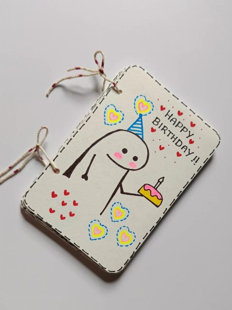 Handmade birthday card with a cute character holding a cake and colorful hearts.